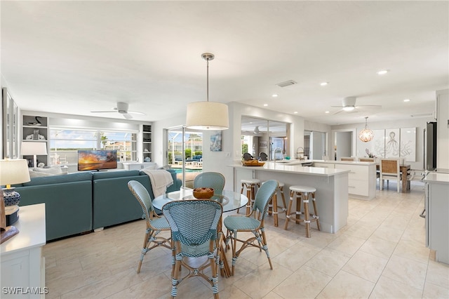 dining room with light tile patterned flooring, built in features, visible vents, and a ceiling fan