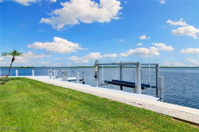 view of dock with a yard, a water view, and boat lift