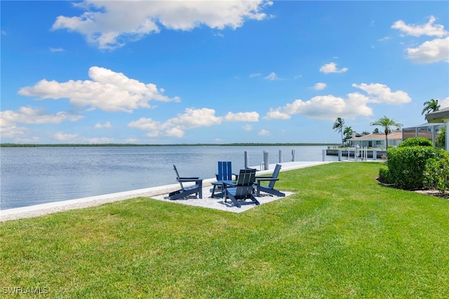 view of dock with a yard, a patio, and a water view