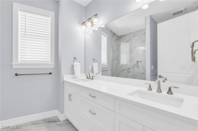 bathroom featuring marble finish floor, a marble finish shower, a sink, and visible vents