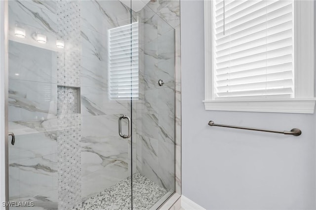 bathroom featuring a marble finish shower