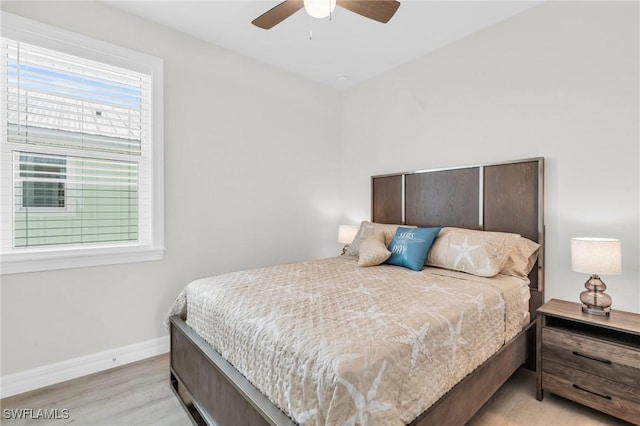 bedroom featuring baseboards, ceiling fan, and light wood finished floors