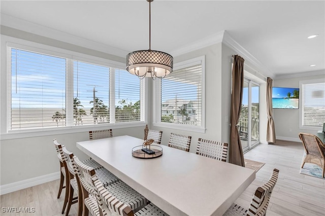 dining room with light wood finished floors, ornamental molding, baseboards, and a healthy amount of sunlight