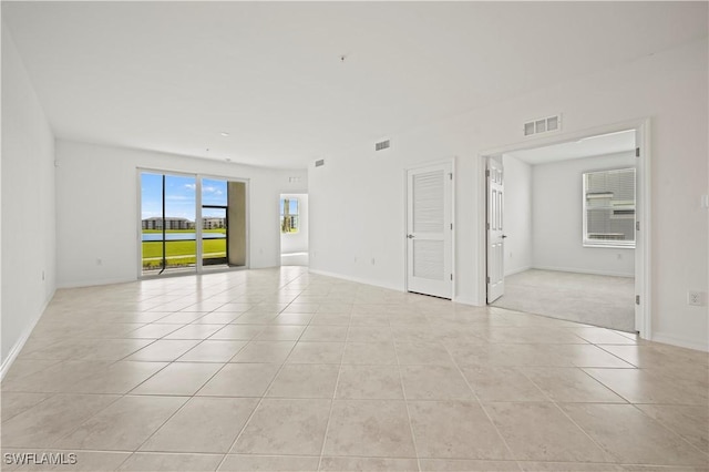 unfurnished room with light tile patterned floors, baseboards, and visible vents