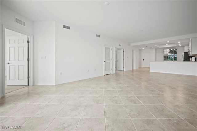 unfurnished living room featuring sink and light tile patterned flooring