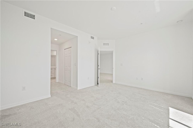 unfurnished room with light carpet, baseboards, and visible vents