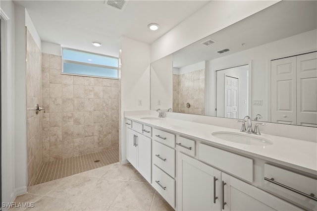 bathroom with tiled shower and vanity