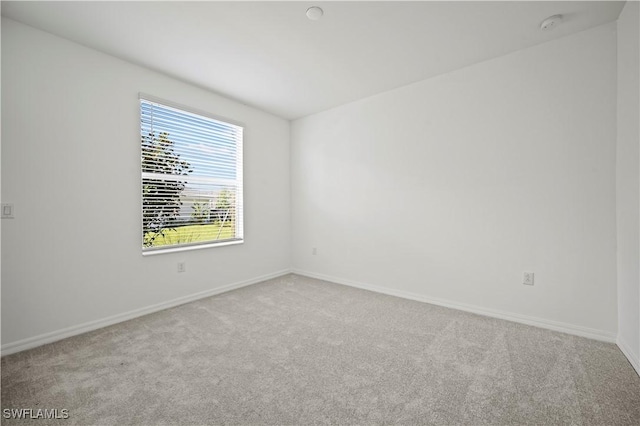 spare room with carpet flooring and baseboards