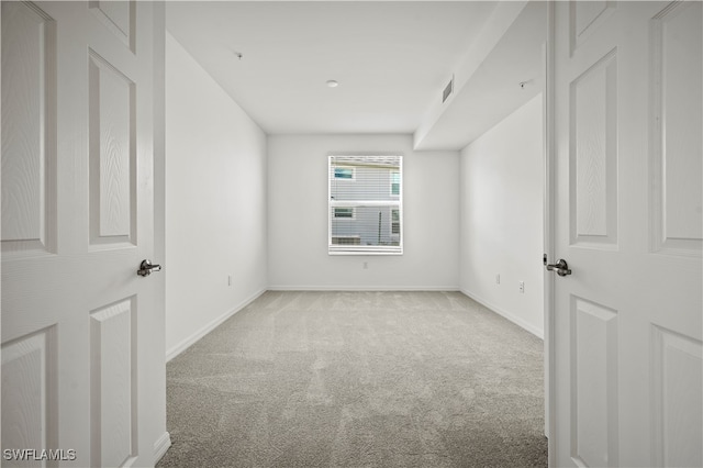 unfurnished room featuring light colored carpet