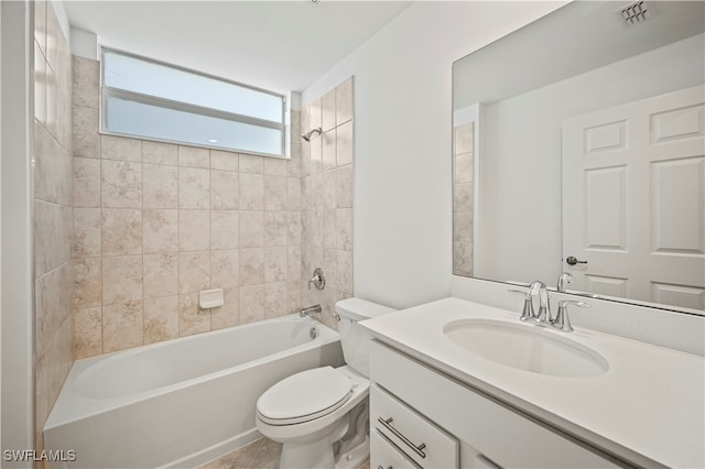 full bathroom featuring tile patterned floors, toilet, tiled shower / bath combo, and vanity