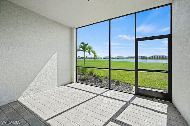 unfurnished sunroom with a water view