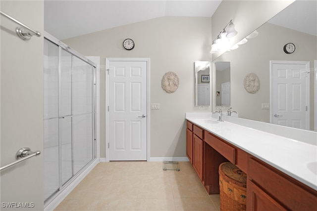 bathroom featuring a shower with door, vanity, lofted ceiling, and tile patterned floors