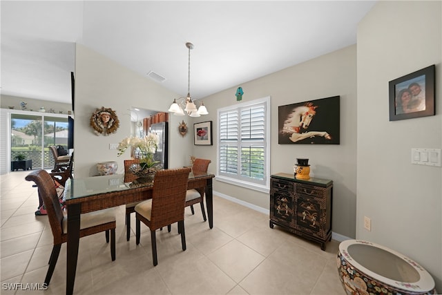 tiled dining area with an inviting chandelier and vaulted ceiling