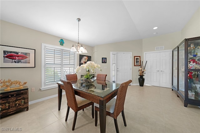 tiled dining area with an inviting chandelier and lofted ceiling