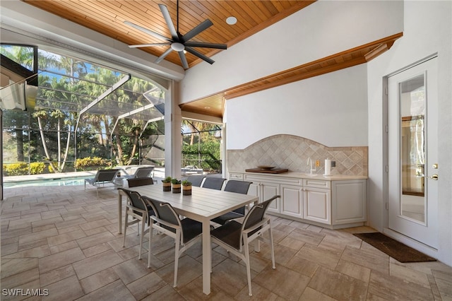 sunroom with ceiling fan, a swimming pool, and wooden ceiling