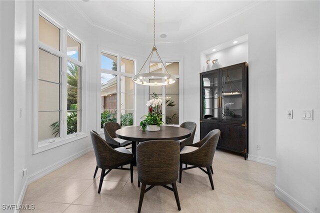 dining space featuring light tile patterned floors, crown molding, and an inviting chandelier