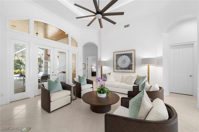 living room with french doors, ornamental molding, ceiling fan, high vaulted ceiling, and light tile patterned flooring