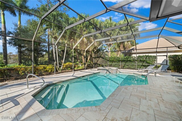 view of pool with an in ground hot tub, a patio, and glass enclosure