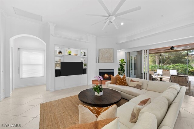 tiled living room featuring ceiling fan and crown molding