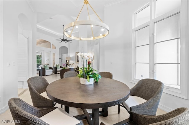 tiled dining area featuring ceiling fan with notable chandelier and crown molding