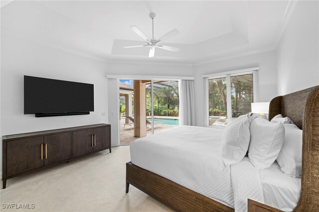 bedroom featuring access to exterior, ornamental molding, light colored carpet, a tray ceiling, and ceiling fan