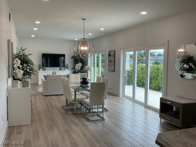 dining space with an inviting chandelier and light wood-type flooring