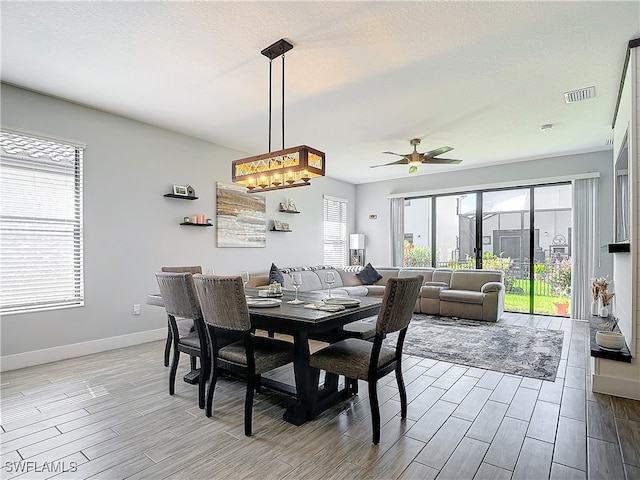 dining area featuring light wood-type flooring, a textured ceiling, and ceiling fan