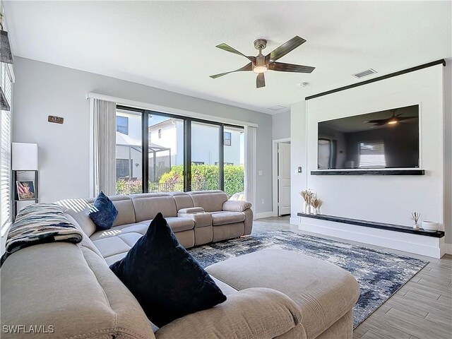 living room with light wood-type flooring and ceiling fan