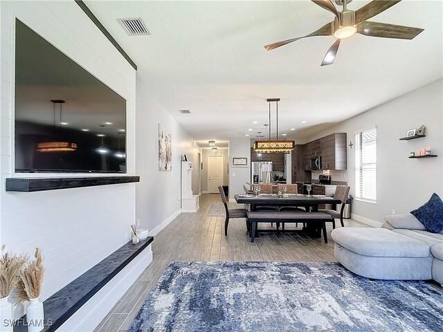 living room with wood-type flooring and ceiling fan