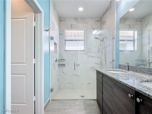 bathroom featuring a shower with door, vanity, and plenty of natural light