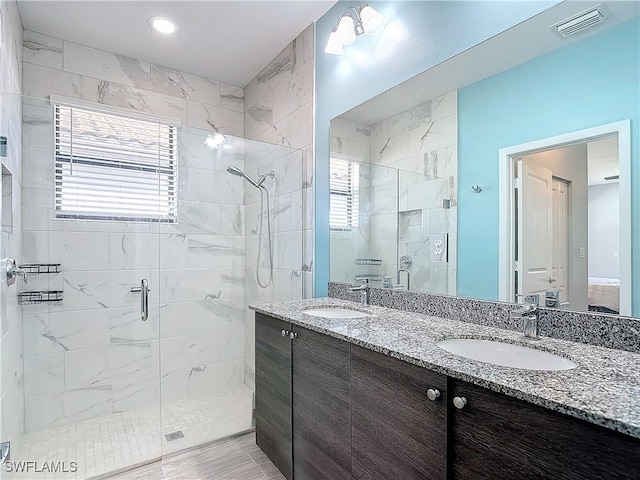 bathroom featuring a shower with door, vanity, and plenty of natural light