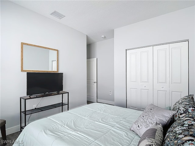 carpeted bedroom with a closet and a textured ceiling