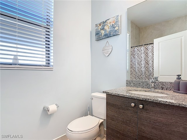 bathroom with vanity, toilet, and walk in shower