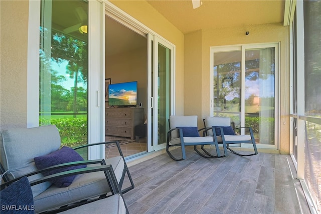 sunroom featuring a textured wall and wood finished floors