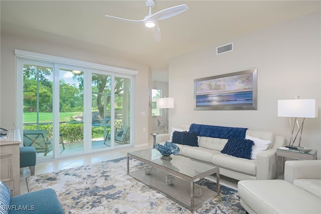 living room featuring a ceiling fan, visible vents, and tile patterned flooring