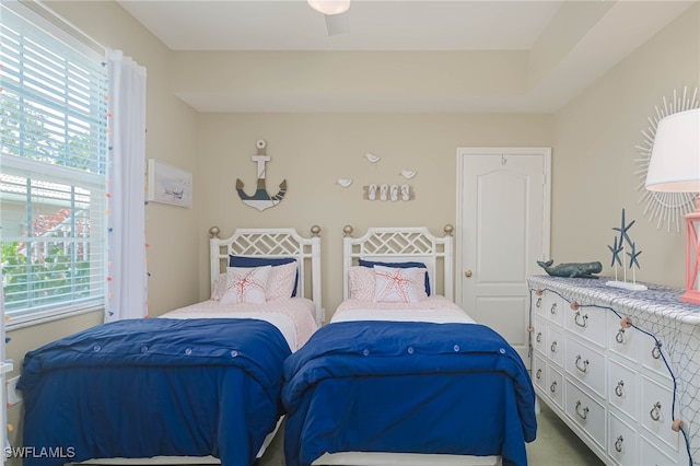 carpeted bedroom with ceiling fan and multiple windows