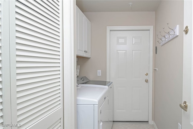 laundry area featuring separate washer and dryer, cabinets, and light tile patterned flooring