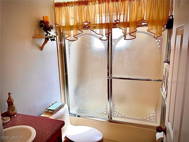 full bathroom featuring shower / bath combination with glass door, vanity, and toilet