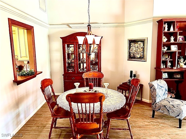 dining room featuring a towering ceiling and hardwood / wood-style floors