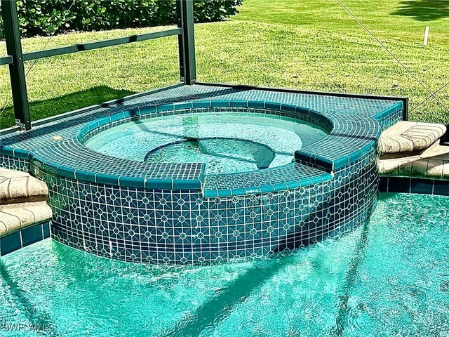 view of pool featuring a yard and an in ground hot tub