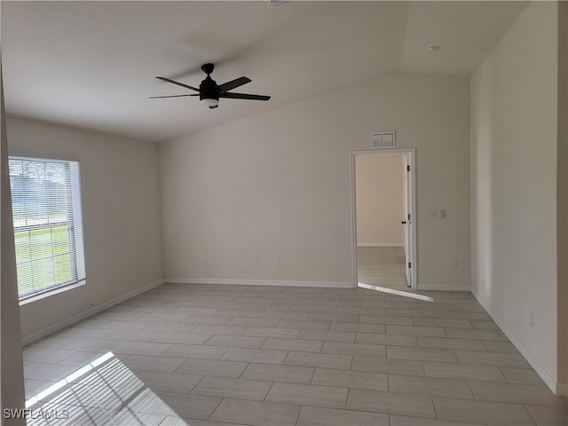 spare room featuring lofted ceiling, light tile patterned floors, and ceiling fan