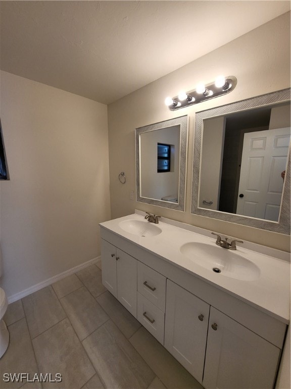 bathroom featuring tile patterned flooring, toilet, and vanity