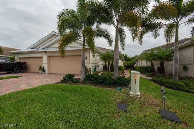 view of front of property featuring a garage, a front yard, and decorative driveway