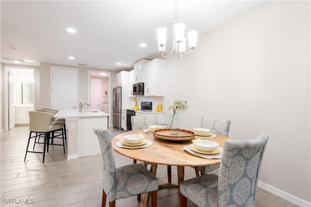 dining space with light wood-style floors, baseboards, a notable chandelier, and recessed lighting