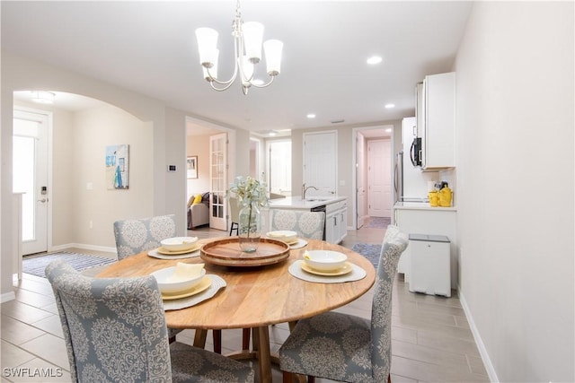 dining room with arched walkways, baseboards, a chandelier, and recessed lighting