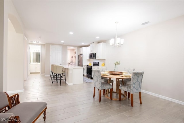 dining room with light wood-style flooring, recessed lighting, visible vents, baseboards, and an inviting chandelier