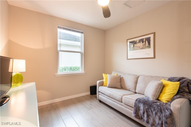 living room with baseboards, visible vents, ceiling fan, and wood finished floors