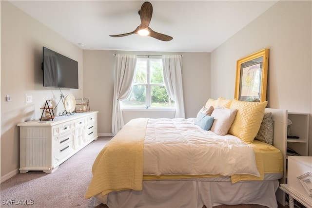 bedroom featuring light carpet, a ceiling fan, and baseboards