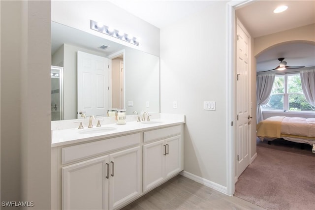 ensuite bathroom featuring double vanity, visible vents, a ceiling fan, and a sink