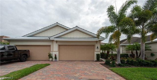 view of front of property featuring decorative driveway, an attached garage, and board and batten siding